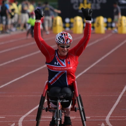 The winner in a wheelchair race at the Wide World of Sports ESPN, Orlando, Florida, United States crosses the finish line with their arms raised over their head in triumph